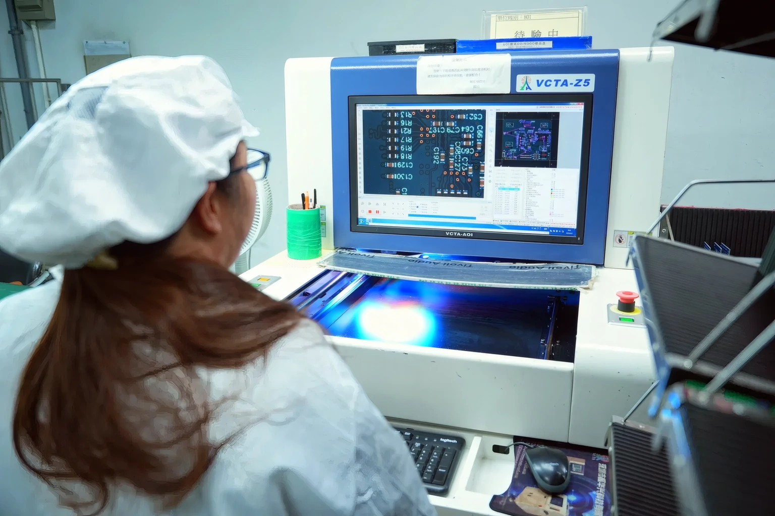 Operator reviewing automated optical inspection results on the SMT line